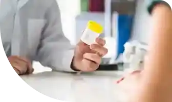 2 people talking, with one holding a urine sample collection cup